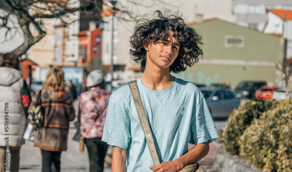 urban teenager  with afro hair walking down the street