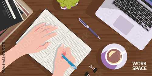 A workspace with a person writing and there are books, laptops, ornamental plants and coffee cups on