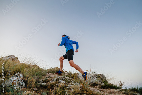 Принти на полотні male runner running uphill in blue sky background
