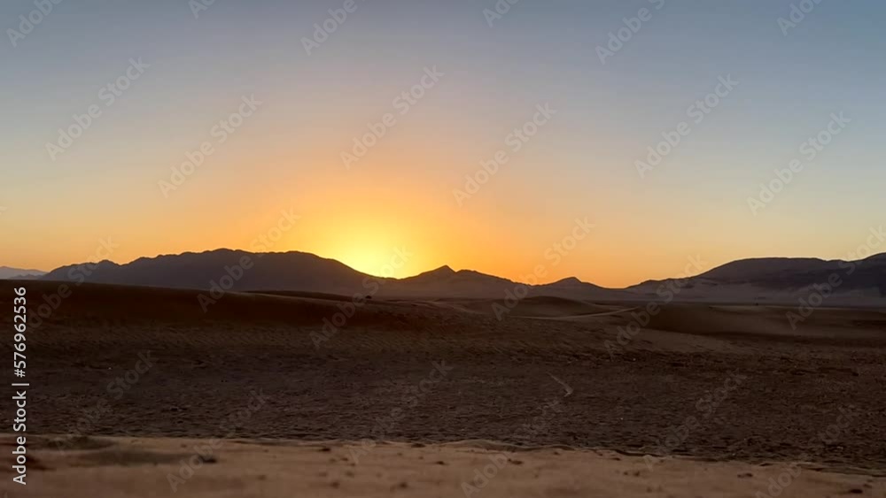 Beautiful sunrise in Sahara Desert with sand dunes and mountains Beautiful sunrise in Sahara Desert with sand dunes and mountains