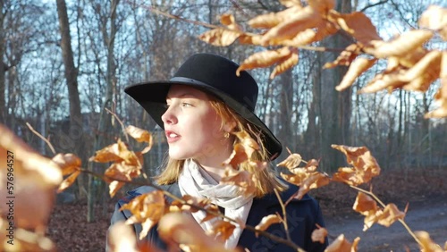 young woman with red hair touching leaf