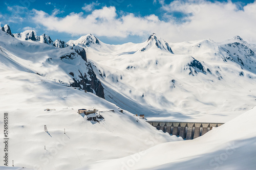 Dam for hydroelectric power production with snow-capped mountains in the background. Ossola, Italy. photo
