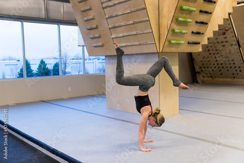 Young fit female in handstand yoga pose photo