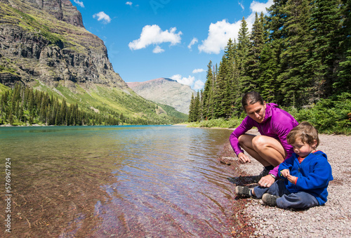 Mother and son playing on shore of Lake Josephine, Glacier National Park, Montana, USA photo