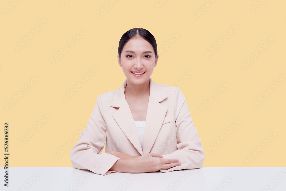 Young businesswoman in a cream suit. Isolate on a pastel yellow background. Young businesswoman in a cream suit. Isolate on a pastel yellow background.