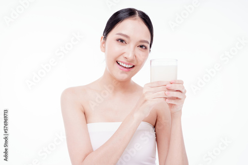 Young happy woman 20s wear white t-shirt hold glass of milk isolated on white background studio. Healthy drink lifestyle concept