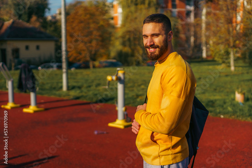 Portrait of a young man smiling, ready for some outdoor work out on a sunny day
