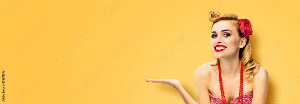 Portrait of happy smiling beautiful woman. Pin up girl show, hold, give, demonstrate, advertise. Vintage ad advertisement concept. Isolated on orange yellow background. Wide banner composition image. Portrait of happy smiling beautiful woman. Pin up girl show, hold, give, demonstrate, advertise. Vintage ad advertisement concept. Isolated on orange yellow background. Wide banner composition image.