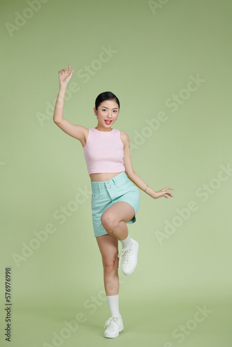 Full-length portrait of amazing asian girl posing with hands up