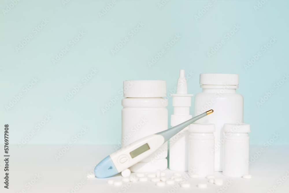 Set of different white medicine bottles, pill bottles without label design, pills, copy space on blue background Set of different white medicine bottles, pill bottles without label design, pills, copy space on blue background