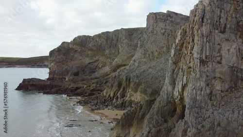 Layered Sea Cliffs as Aerial Shot Rises to Reveal Small Enclosed Bays and Coastal Erosion 4K Wales UK photo