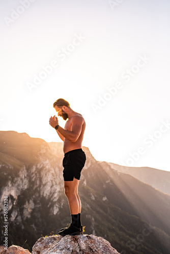 An athlete rests on top of a mountain after exhausting running training. © Minet