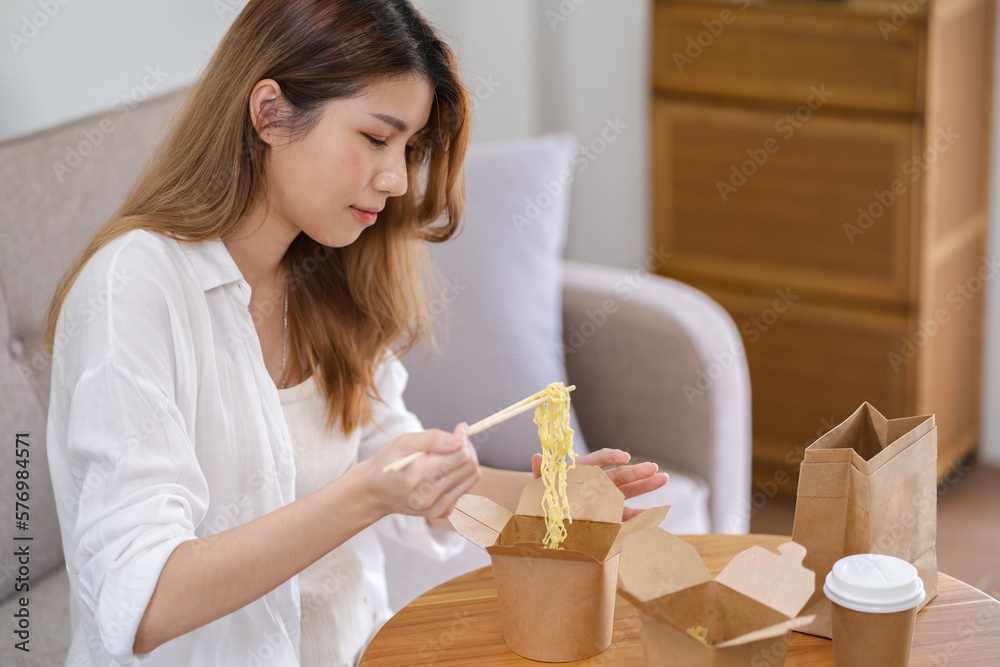 Asian woman with takeaway food and drinks at home. consumption eating home delivery food. enjoying delicious takeaway delivery tasty meal