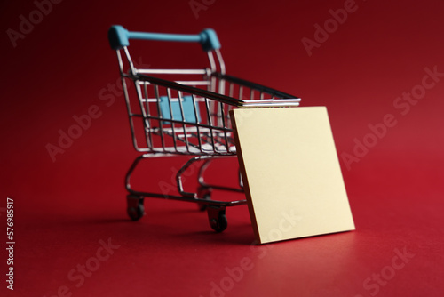 Shopping cart with blank adhesive note paper on red background