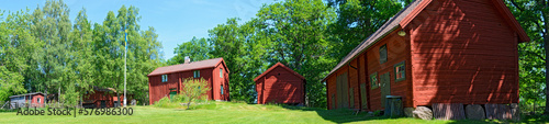 old wooden houses painted with traditional falunred color at an open-air museum in Sweden photo