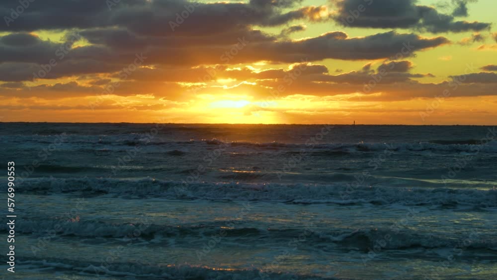 Evening landscape of sea water waves crushing on sandy beach at sunset Evening landscape of sea water waves crushing on sandy beach at sunset