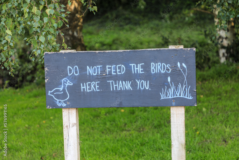 A sign saying 'do not feed the birds here thank you' England, UK
