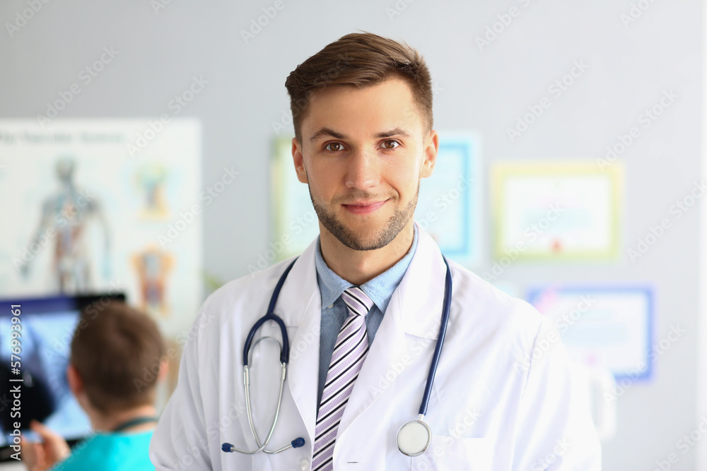 Friendly male general practitioner standing in office Friendly male general practitioner standing in office