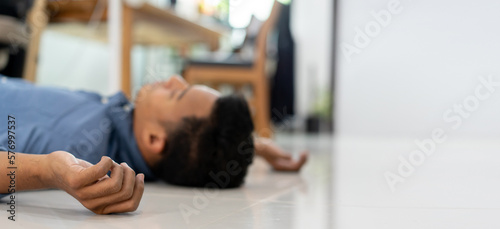 close up adult man hand lying on home's floor in living room after got fainted symptom from heart attack syndrome for health lifestyle concept