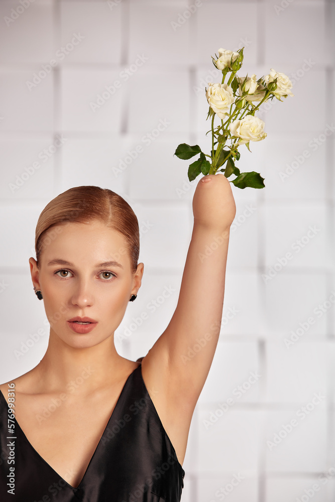 Beautiful young disabled woman with a flower instead of a hand raised up, holding a flower in her hands in a black dress. Diversity disability and flowers. Beautiful young disabled woman with a flower instead of a hand raised up, holding a flower in her hands in a black dress. Diversity disability and flowers.