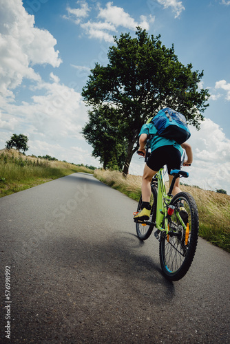 Fototapeta Naklejka Na Ścianę i Meble -  Kleiner Junge geht aus dem Sattel beim Beraufsprint auf einer Fahrradtour durch Niedersachsen in den Sommerferien, Deutschland