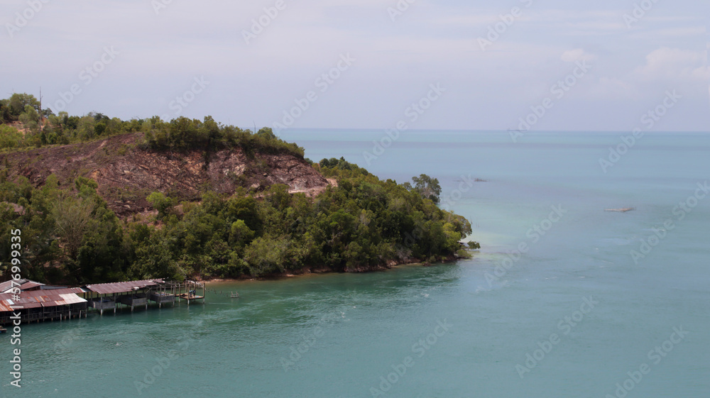 Floating village at the sea shore with blue water, hilly nature background.