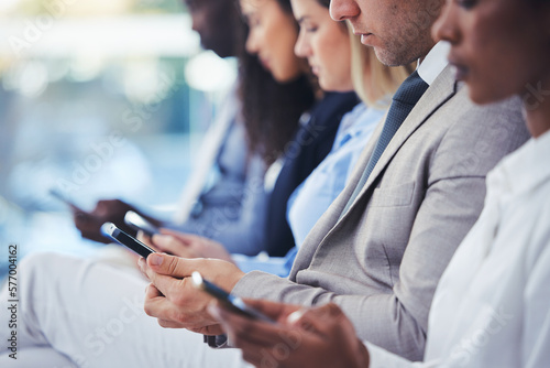 Hands, phone and hr with a group of people waiting in line for an interview or meeting. Mobile, hiring and recruitment with business collegues sitting in a human resources candidate shortlist row photo