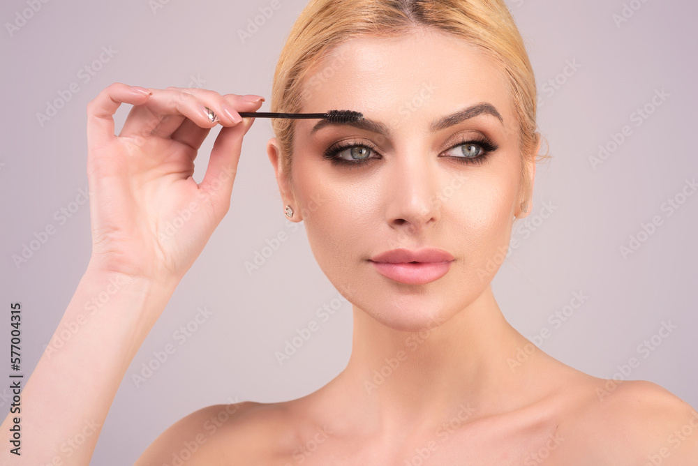 Eyebrow makeup. Beauty model shaping brows with brow pencil closeup. Womans eyebrows with eyebrow brush. Natural make up. Modeling brows. Comb eyebrows.