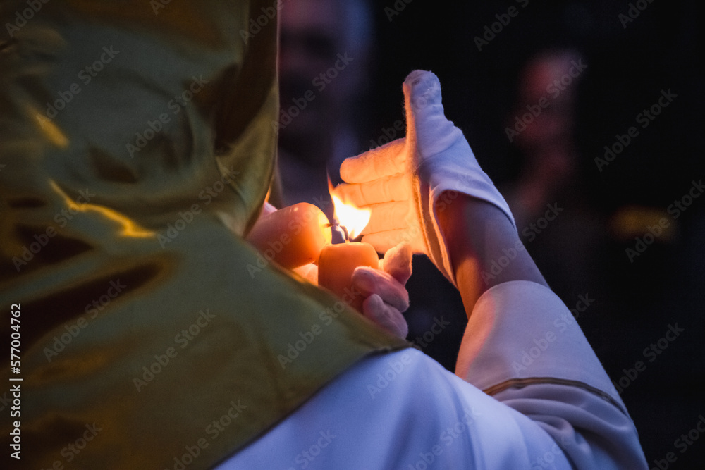 nazareno with candle illuminating the procession on the night of holy friday - obrazy, fototapety, plakaty 