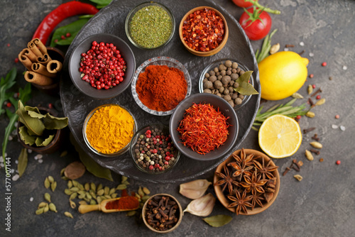 Fototapeta Naklejka Na Ścianę i Meble -  Set of spices and herbs. Indian food. Pepper, salt, paprika, basil, turmeric. On a black wooden board. View from above. Free copy space.