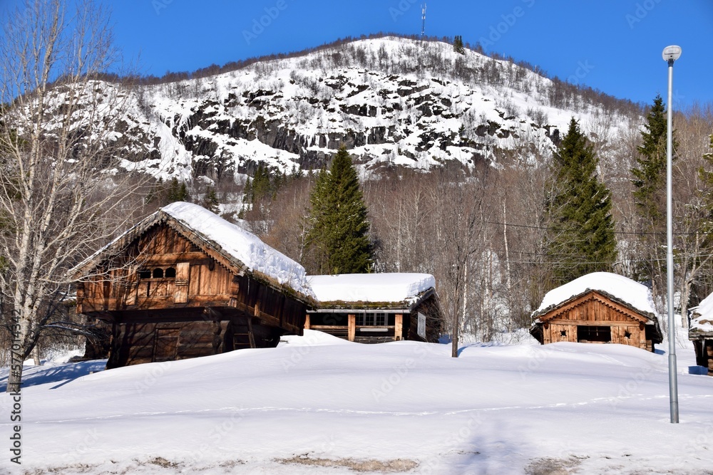 Bykle, Norway, February 23, 2023. Traditional Norwegian Wooden buildings in the snow with mountains behind. 