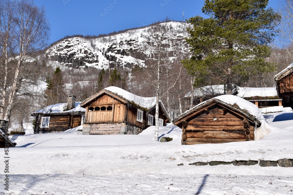 Bykle, Norway, February 23, 2023. Traditional Norwegian Wooden buildings in the snow with mountains behind. 