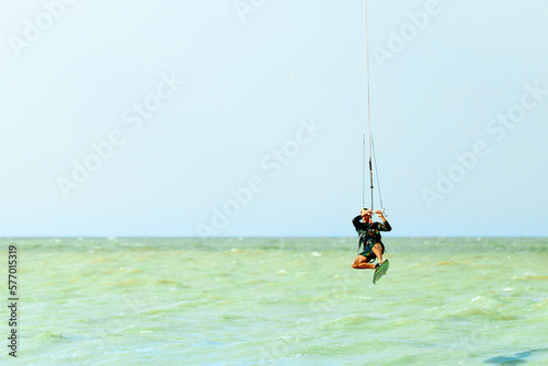 Young kitesurfer jumping in the sky on the board