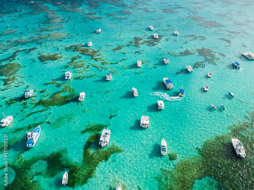 Fototapeta Naklejka Na Ścianę i Meble -  Many anchoring yachts and tourist boats in the turquoise Caribbean sea. Punta Cana, Dominican Republic