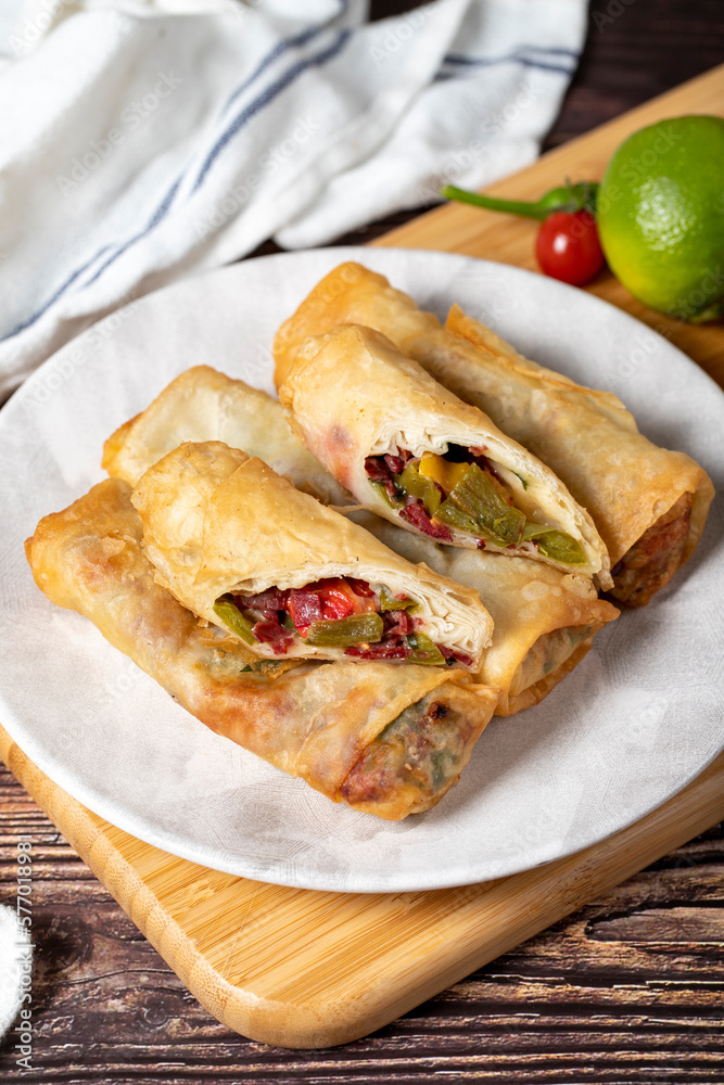 Pacanga pastry. Turkish cuisine delicacies. Pastry made with phyllo, tomato, green pepper, capia pepper, cheddar cheese and pastrami. Ramadan food. Local name paçanga boregi. Close up Pacanga pastry. Turkish cuisine delicacies. Pastry made with phyllo, tomato, green pepper, capia pepper, cheddar cheese and pastrami. Ramadan food. Local name paçanga boregi. Close up