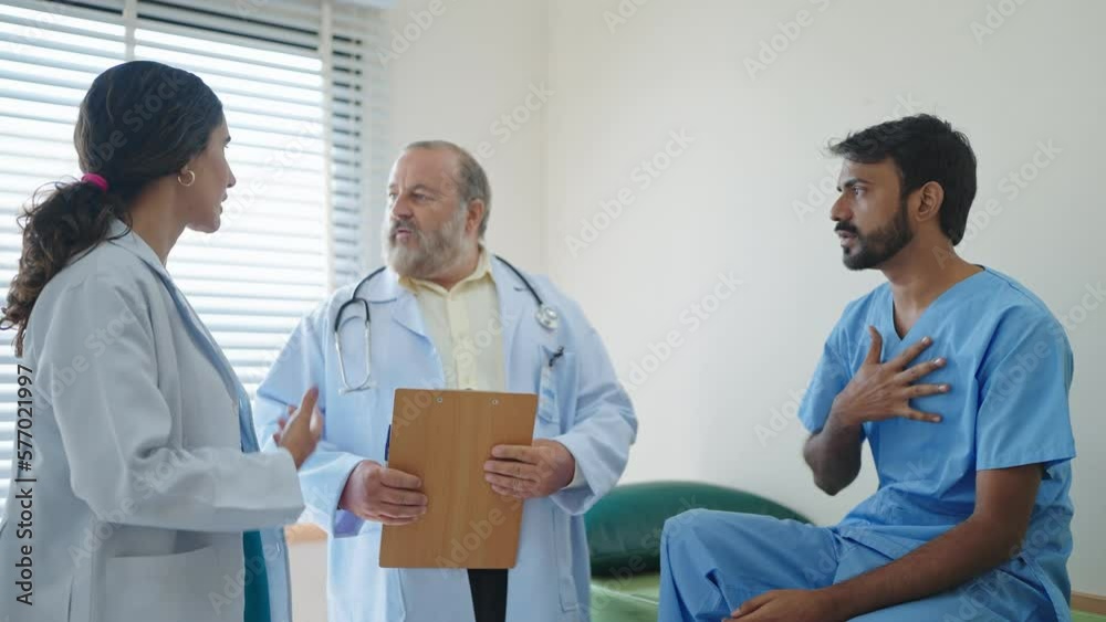 Professional woman doctor and asian senior male doctor talking and encourage an Indian male patient has been treated with doctor at the hospital Professional woman doctor and asian senior male doctor talking and encourage an Indian male patient has been treated with doctor at the hospital