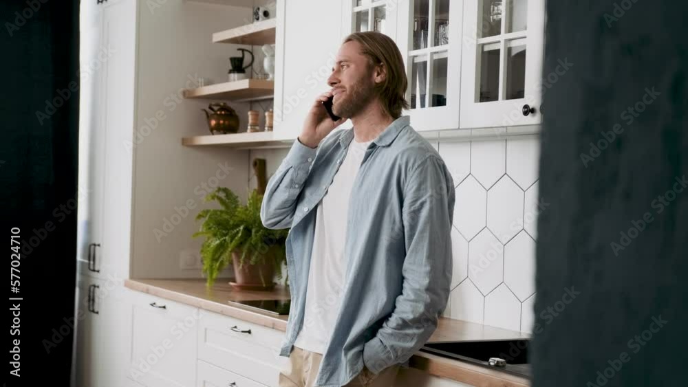 A man is talking on the phone and smiling at work A man is talking on the phone and smiling at work
