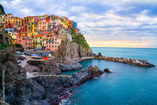 Stunning view of Manarola village in Cinque Terre National Park, beautiful cityscape with colorful houses and green terraces on cliffs over a sea, Liguria region of Italy. Outdoor travel background