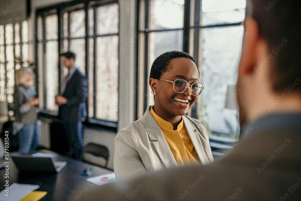 Shot of two businesspeople shaking hands during a meeting in an office. Focus on a smiling black businesswoman Shot of two businesspeople shaking hands during a meeting in an office. Focus on a smiling black businesswoman