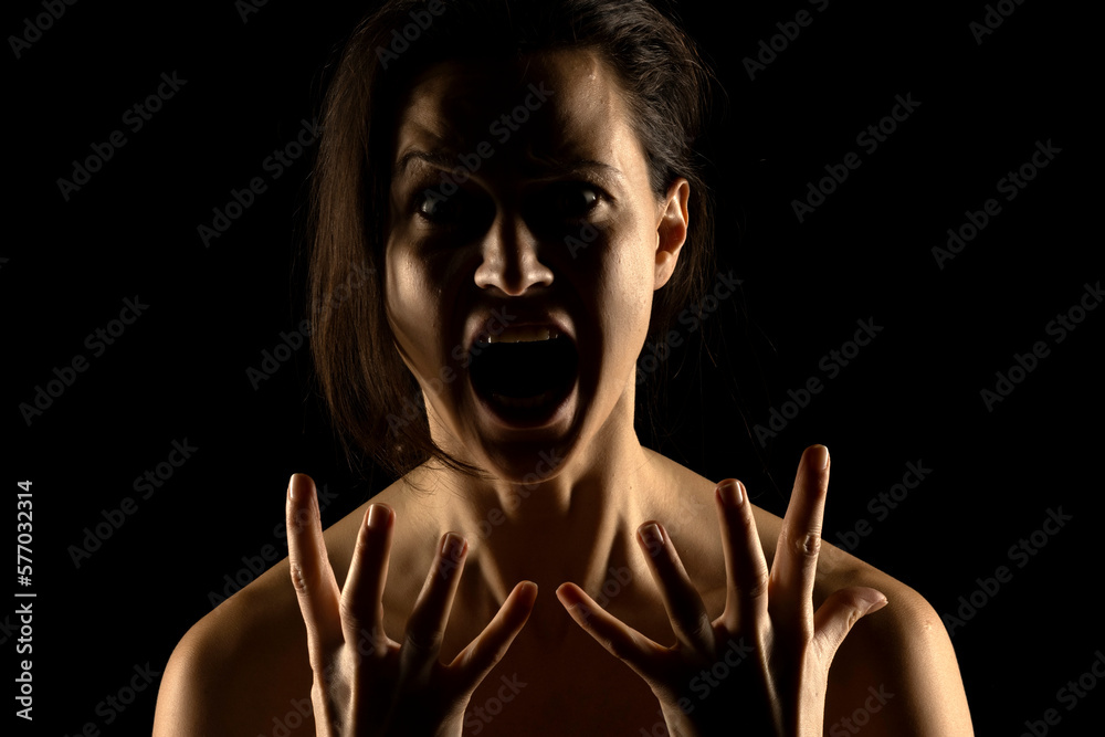 Silhouette of young unhappy screaming woman on black background