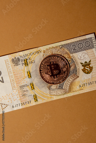 Bitcoin gold coin on bills of 200 polish zloty currency. Bitcoin mining trading concept. BTC golden money. Worldwide virtual internet Cryptocurrency or crypto digital payment system. Digital coin photo