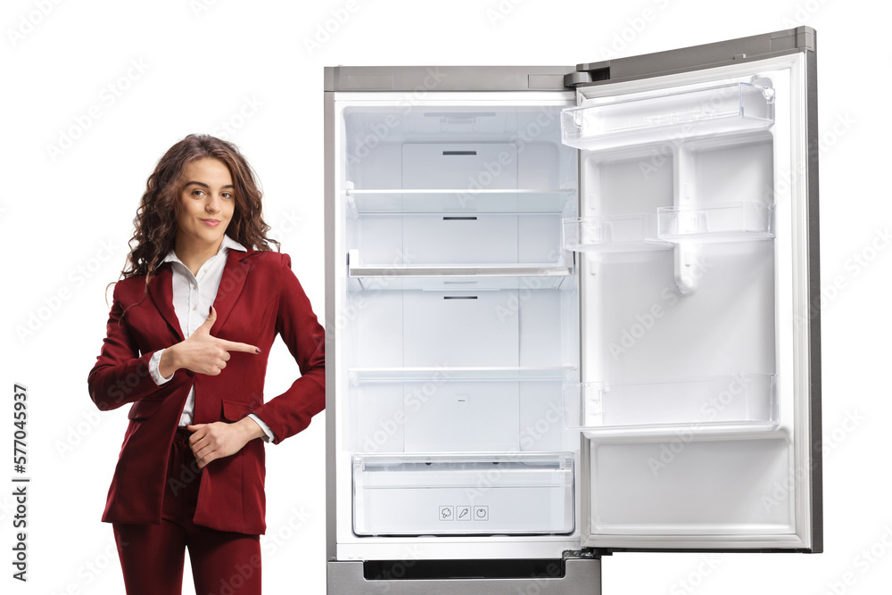 Young saleswoman pointing at an empty open fridge Young saleswoman pointing at an empty open fridge