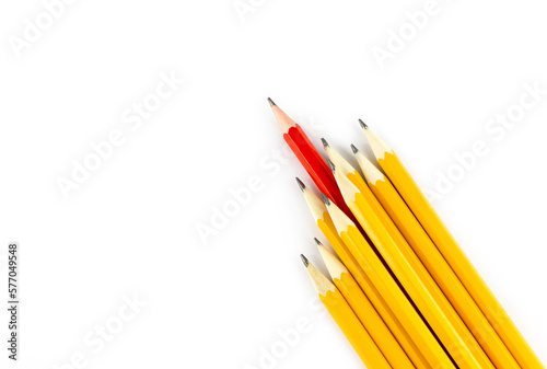 One red pencil standing out from the row of yellow pencils isolated on white background