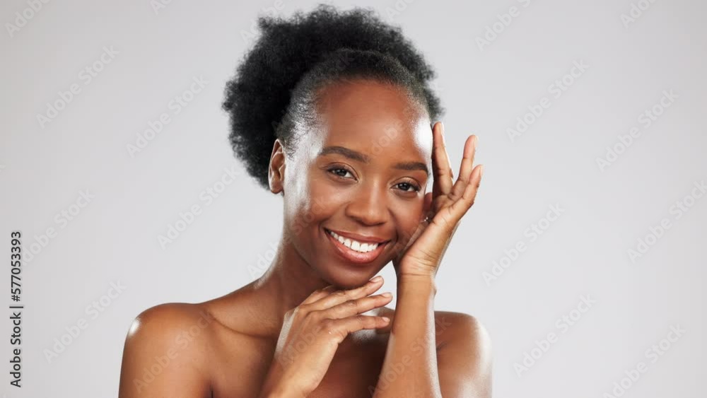 Beauty, portrait and black woman with a glow from skincare isolated on grey studio background. Cosmetic, smile and African girl touching her face for a soft, feminine and clear complexion and mockup