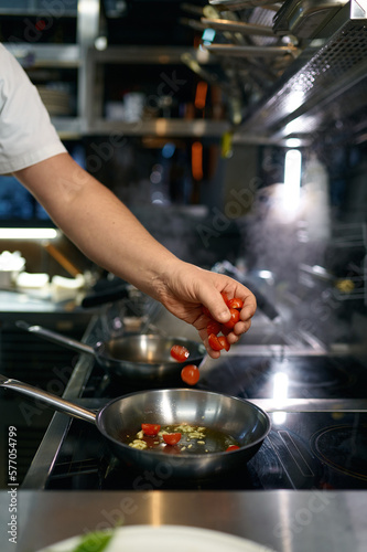 Master chef preparing tomato sauce for pasta in frying pan