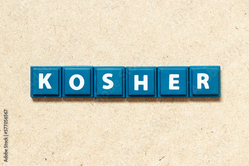 Tile alphabet letter in word kosher on wood background photo