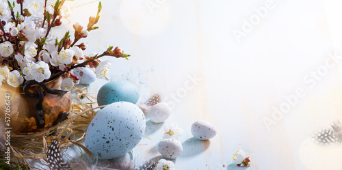 Canvas Print Happy Easter;  Easter eggs and natural sprig flowers on blue table background