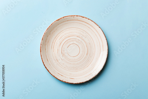 Top view of isolated of colored background empty round beige plate for food. Empty dish with space for your design