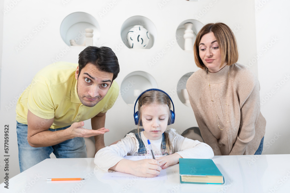 Fototapeta premium Portrait of happy family with child daughter studying at home. Home education and parents support concept