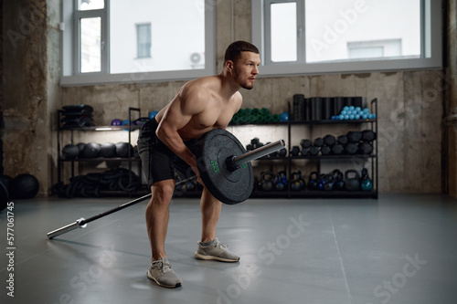 Foto Strong man prepares to lift heavy weights training with barbell
